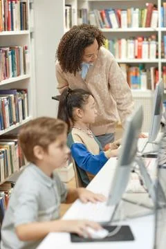 Teacher Helping Kids using Computers in It Class Stock Photos