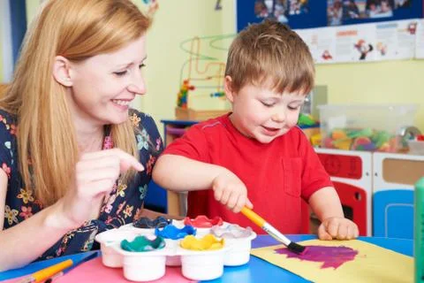 Teacher Helping Preschool Child In Art Class Stock Photos