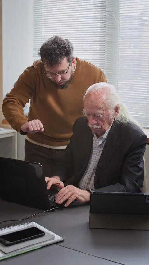 Teacher Helping Senior Man in Computer Class Vertical Stock Footage 333710832