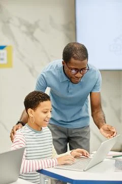 Teacher Helping Student in Class 库存照片