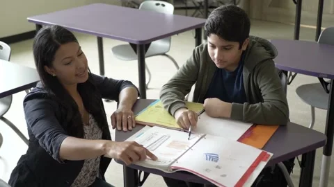 Teacher helping student in classroom Stock Footage 221034436