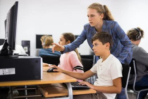 Teacher helping student with computer work 스톡 사진