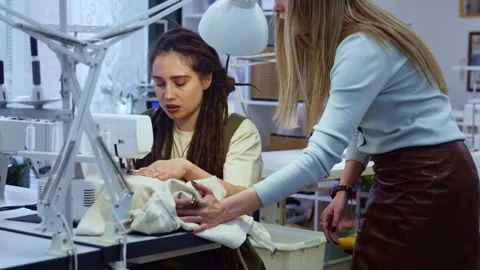 Teacher helping a student at a sewing machine Vídeos de archivo 336247617