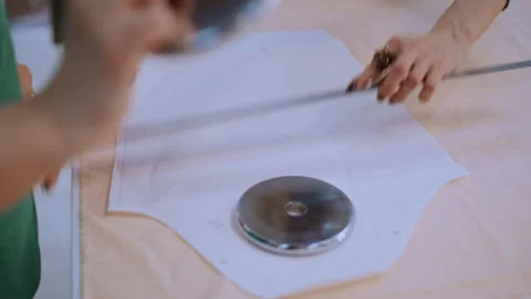 Teacher helping student with a sewing pattern in a studio Видео 335931227