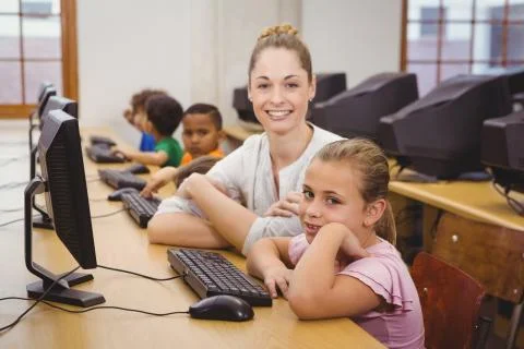 Teacher helping a student using a computer Stock Photos