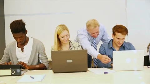 Teacher helping students in classroom Stock Footage 33290293