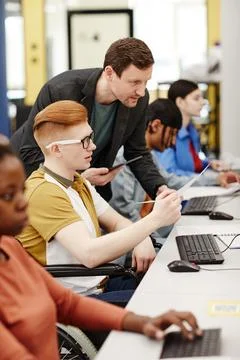 Teacher Helping Students in Computer Lab Foto stock