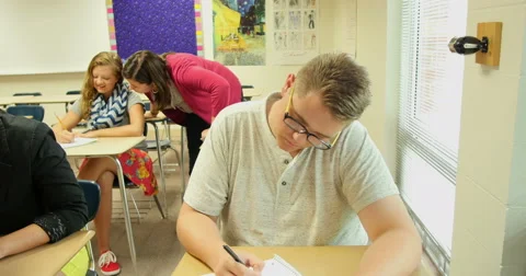 Teacher helping students with their school assignments and homework. Ultra HD 4K Stock Footage 45621955