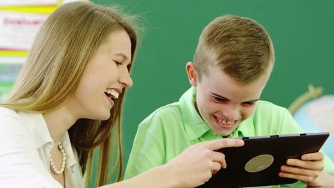 Teacher helping young boy using tablet Stock-Footage 80131388