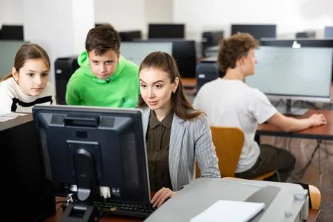 Teacher helping young student in computer class Stock Photos