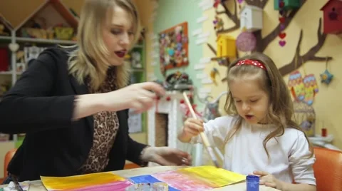 The teacher helps the little girl to paint Stock Footage 59595097