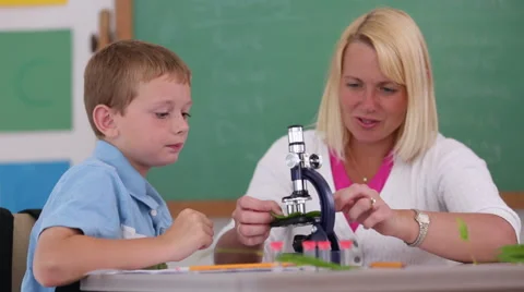 Teacher helps student with microscope Video stock 62344222