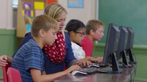 Teacher helps students in computer class Video stock 68961562