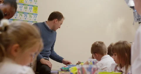 Teacher interacting with children in classroom Stock Footage 58573125
