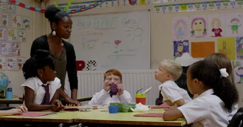 Teacher interacting with children in classroom Stock Footage 58574384
