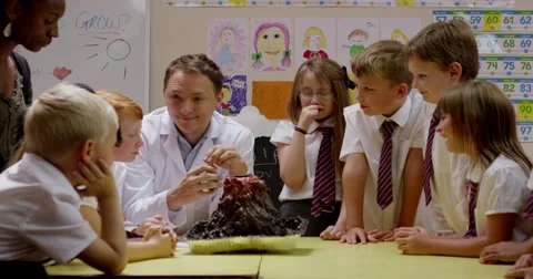Teacher interacting with children while working on a science project Stock Footage 58573548