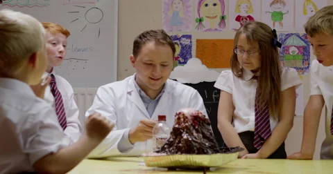 Teacher interacting with children while working on a science project Stock Footage 58573557