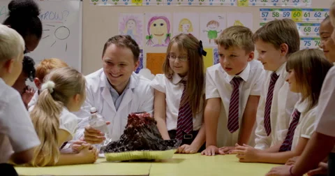 Teacher interacting with children while working on a science project Stock Footage 58573566
