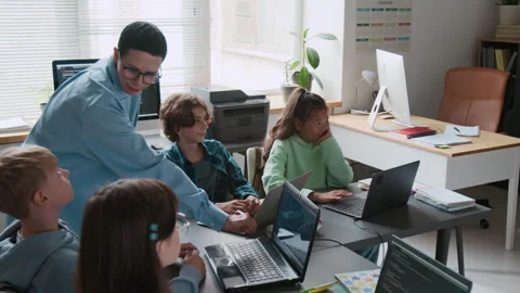 Teacher Interacting with Group of her Students During IT Class in School Stock Footage 317641888