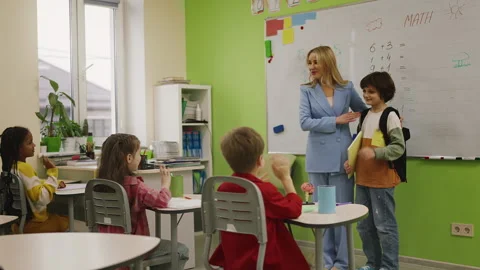 Teacher introducing new student to classmates in classroom, school life moment Stock Footage 333585427