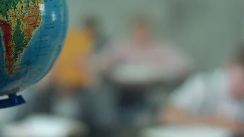 Teacher with kids in geography class looking at globe Stock Footage