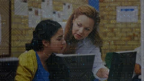 Teacher leaning over student at computer lab, pointing at monitor and guiding Stock Footage 330540859