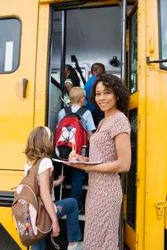 Teacher Loading Elementary Students On School Bus Stock Photos