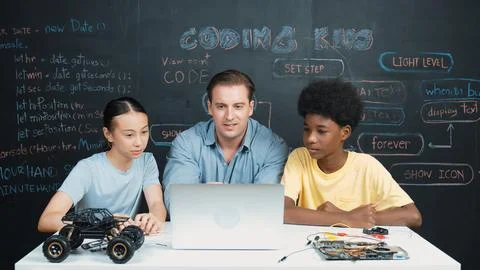 Teacher looking at laptop while teaching about engineering code. Edification. Stockfoto's