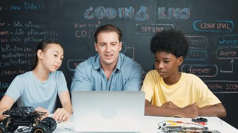 Teacher looking at laptop while teaching about engineering code. Edification. Foto stock