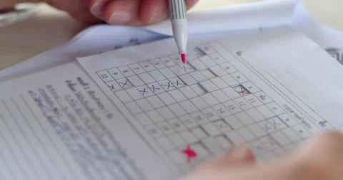 Teacher marking student exam papers with a red pen using a prepared answer sheet Stock Footage 317756936