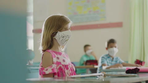 Teacher measures the students temperature with a non-contact infrared thermom Stock Footage 137555625