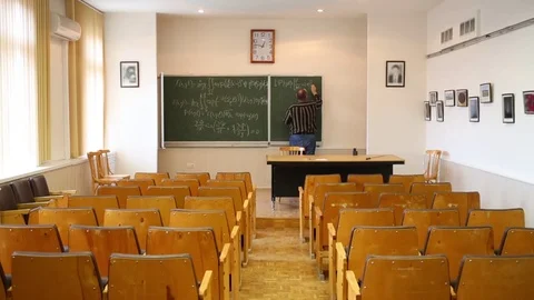 Teacher (with model release) writing complex equations on blackboard Stock Footage 69988619