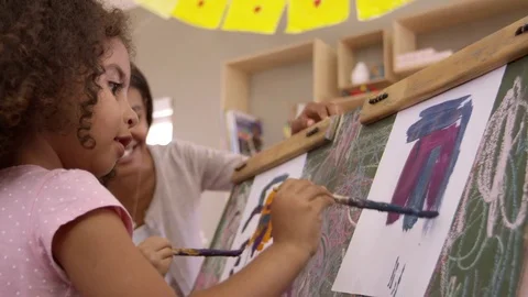 Teacher At Montessori School Helping Children in Art Class Stock Footage