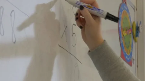 Teacher multiplying on white board. Maths lesson. Stock Footage 73480165