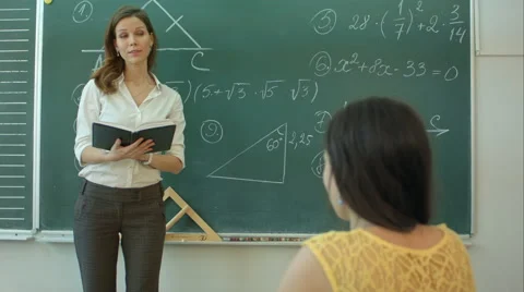 Teacher or docent or educator giving while lesson in front of a blackboard or Vídeos de archivo 66006723