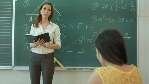 Teacher or docent or educator giving while lesson in front of a blackboard or Stock Footage 152865751