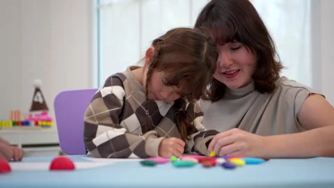 Teacher or parent helping a child color the picture with color pencil 動画素材 339565040