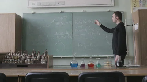 Teacher or student explaining decision of chemical equations in classroom Stock Footage 86257517