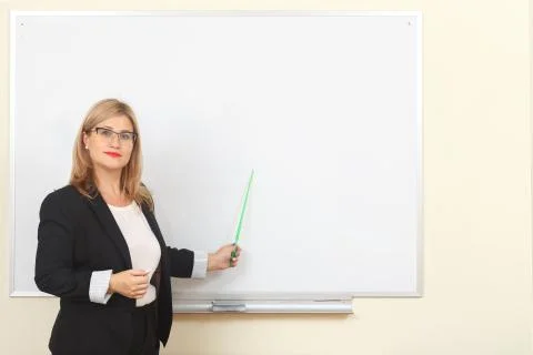 A teacher with a pointer points at the blackboard Stock Photos