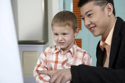  Teacher pointing to computer screen with student Beijing China Copyright:... Stock Photos