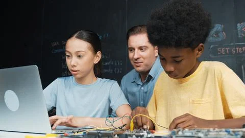 Teacher pointing at laptop while teaching about engineering code. Edification. Stockfoto's
