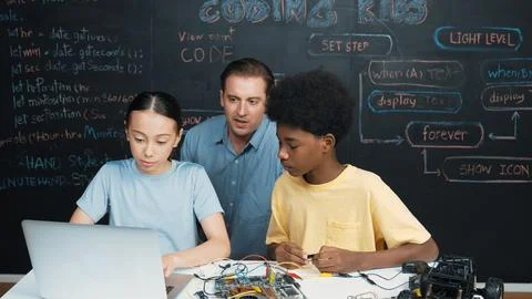 Teacher pointing at laptop while teaching about engineering code. Edification. Foto stock