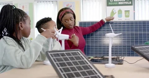 Teacher pointing to solar panel and poster, explaining power while youth 스톡 동영상 341062996