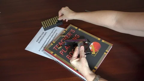 Teacher preparing to arm herself in the school classroom Stock Footage 86996841