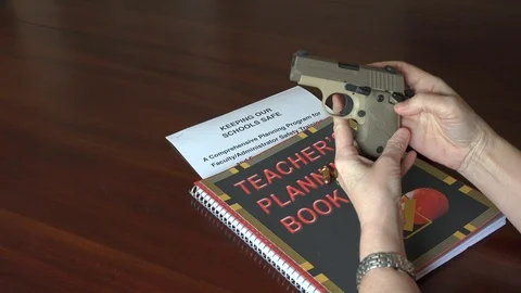 Teacher preparing to arm herself in the school classroom. 4K Vídeo Stock 87296346