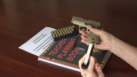 Teacher preparing to arm herself in the school classroom. 4K Stock Footage 87296352