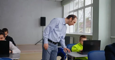 Teacher Of Programming And Coding Courses For Children Walking In Classroom Stock-Footage 280174666