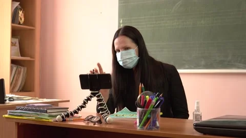 The teacher in a protective mask. Video tutorial during quarantine. A young Stock Footage 138398920