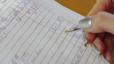 A teacher is putting a mark to the diary Stock Footage 85561431