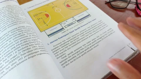 Teacher reading a book for the students on the table in the class room Video stock 211563231